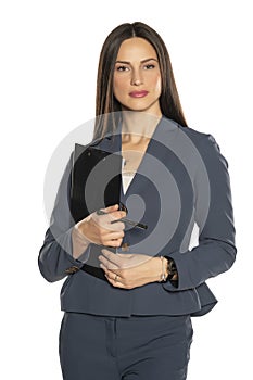 Beautiful young serious business woman in a pants and jacket with notepad