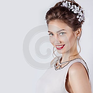 Beautiful young elegant happy smiling woman with red lips, beautiful stylish hairstyle with white flowers in her hair