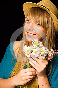 The beautiful young girl with flowers in the hand