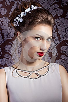 Beautiful young sweet girl with large red lips in wedding white wreath on the head with beautiful wedding hairstyle