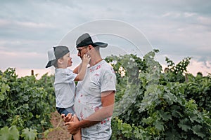 Beautiful young smiling family boy and father having fun at a vineyard
