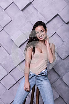 Beautiful young smiling fashion model posing in photo studio