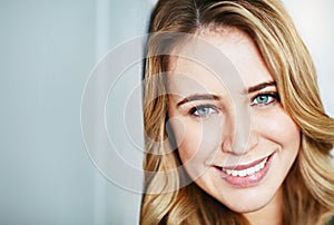 Beautiful, young and smiling female face looking happy and confident with copyspace. Closeup of a blonde natural beauty