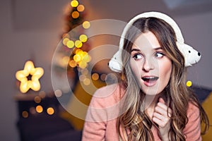 Beautiful young smiling woman at Christmas listening to music