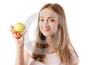 Beautiful young smiling woman holding an apple and measuring centimeter in hands
