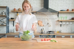 Beautiful young smiling woman making salad in the kitchen. Healthy food. vegetable salad. Diet. Healthy lifestyle. cooking at home