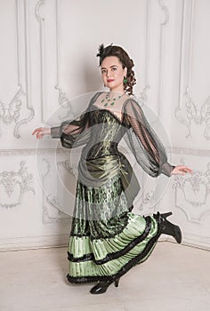 Beautiful young smiling woman wearing green medieval vintage Victorian Style dress dance