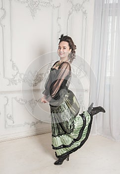 Beautiful young smiling woman wearing green medieval vintage Victorian Style dress dance