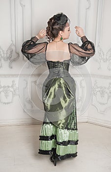 Beautiful young smiling woman wearing green medieval vintage Victorian Style dress turn