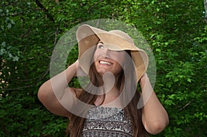 Beautiful young smiling woman in wide hat