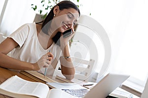 Beautiful young smiling woman working on laptop from home office space