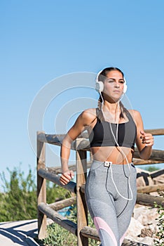 Beautiful young sports Woman running jogging in a park outdoors listening music