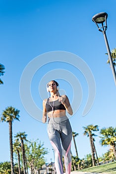 Beautiful young sports Woman running jogging in a park outdoors listening music