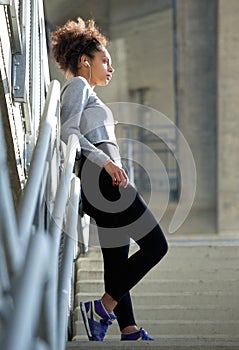 Beautiful young sports woman standing alone with earphones