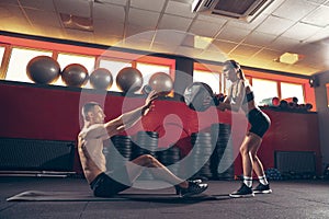 Beautiful young sporty couple training, workout in gym together