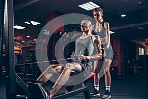 Beautiful young sporty couple training, workout in gym together