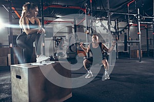 Beautiful young sporty couple training, workout in gym together