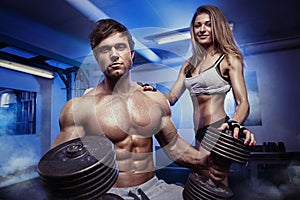 Beautiful young sporty couple workout in gym