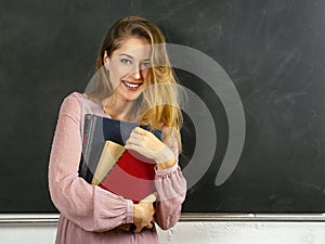 Beautiful young student in front of blackboard