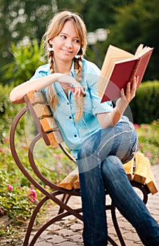 Beautiful young student girl reading book