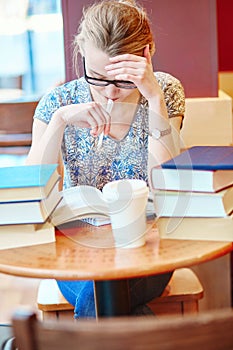 Beautiful young student with lots of books