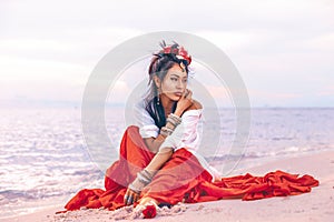 Beautiful young stylish boho woman on the beach at sunset