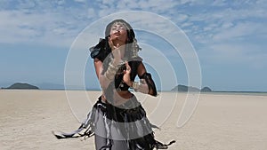 Beautiful young stylish tribal dancer. Woman in oriental costume dancing outdoors