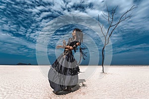 Beautiful young stylish tribal dancer. Woman in oriental costume dancing outdoors