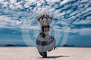 Beautiful young stylish tribal dancer. Woman in oriental costume dancing outdoors