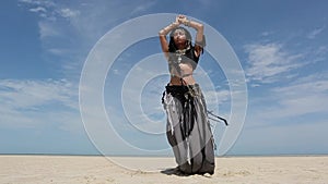 Beautiful young stylish tribal dancer. Woman in oriental costume dancing outdoors