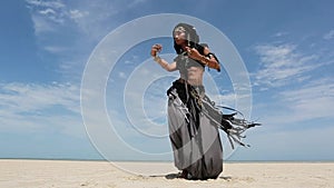 Beautiful young stylish tribal dancer. Woman in oriental costume dancing outdoors