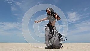 Beautiful young stylish tribal dancer. Woman in oriental costume dancing outdoors