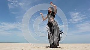 Beautiful young stylish tribal dancer. Woman in oriental costume dancing outdoors