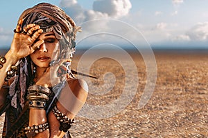 Beautiful young stylish tribal woman in turban outdoors at sunset