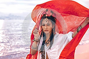 Beautiful young stylish woman on the beach at sunset