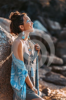 Beautiful young stylish woman on the beach at sunset