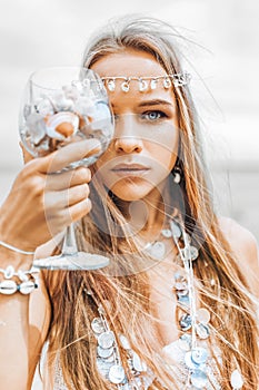 Beautiful young stylish woman close up portrait with glass full of sea shells