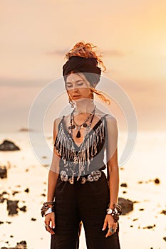 Beautiful young stylish woman posing at sunset