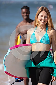 beautiful young surfer girl in bikini with surfboard at beach
