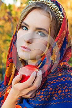 Beautiful young sweet girl in a headscarf with the rim on the head with a red Apple in his hand, like a fairy tale character