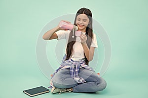 Beautiful young teen child drinking a hot drink from a thermo mug. Happy teenager with thermos and mug, positive and