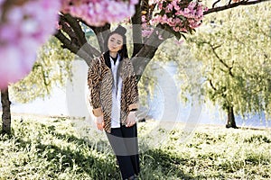 beautiful young teen girl in spring blooming cherry blossoms garden