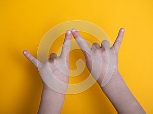 A beautiful young teen shows her horns up with a gesture