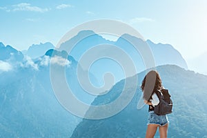 Beautiful young tourist girl with backpack at mountains