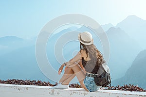 Beautiful young tourist girl with backpack at mountains