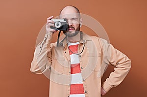 A beautiful young tourist, a photographer on a brown background