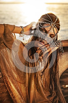 beautiful young tribal style woman outdoors at sunset