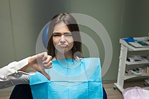 Beautiful young upset brunette patient woman having examination at dental office showing dislike sign, looking unhappy, healthcare