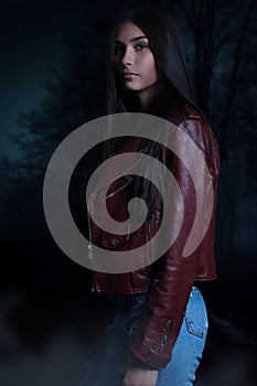 Beautiful young vampire woman on a dark vampire photo