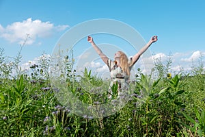 Beautiful young vital woman enjoying in nature in the fresh air. Joy. Freedom. Happiness. Lust raises her arms